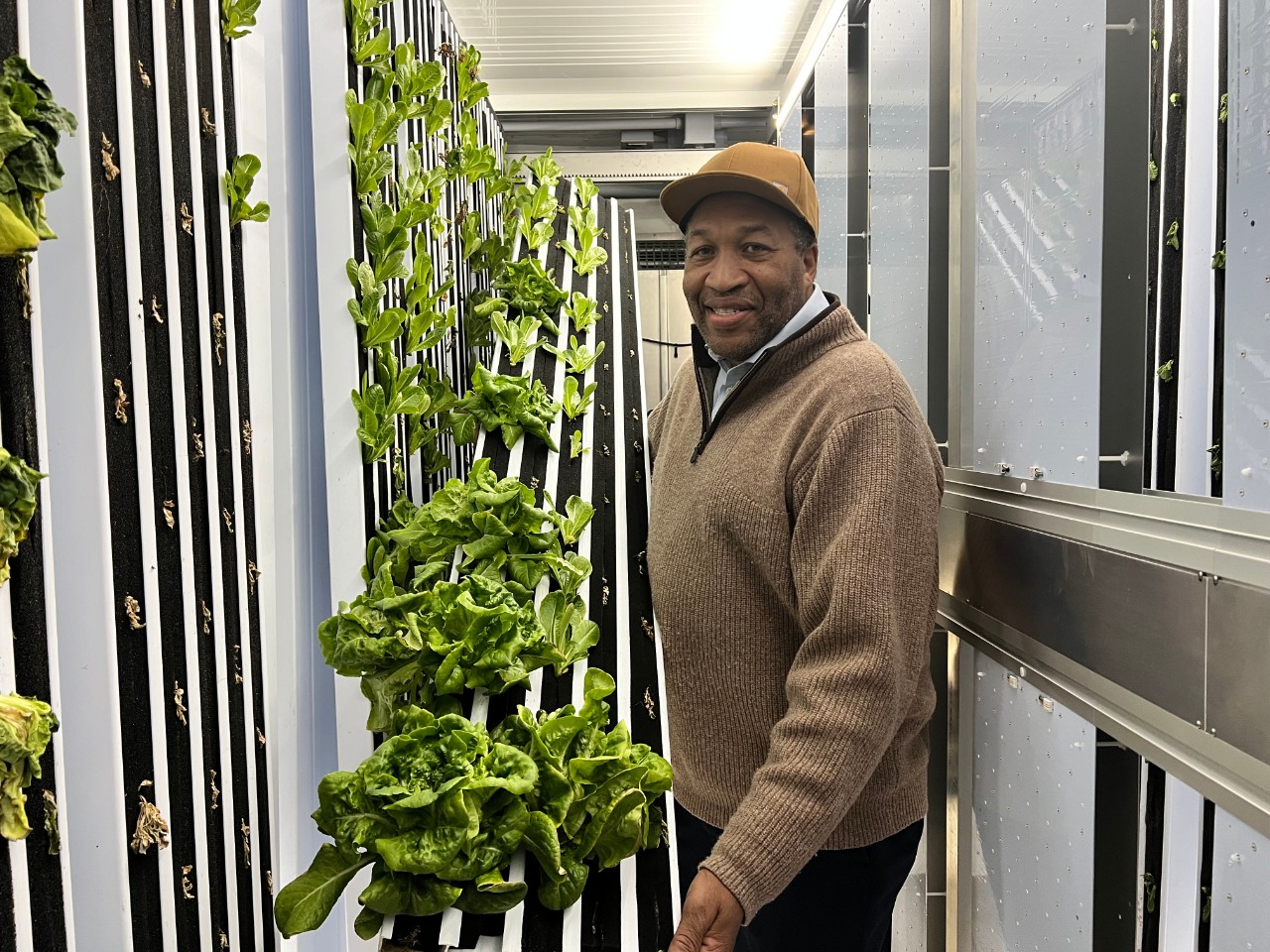 Charles Luster holding vegetables from 2Gether We Eat freight farm. (Spectrum News 1/Kyra Ceryanek)